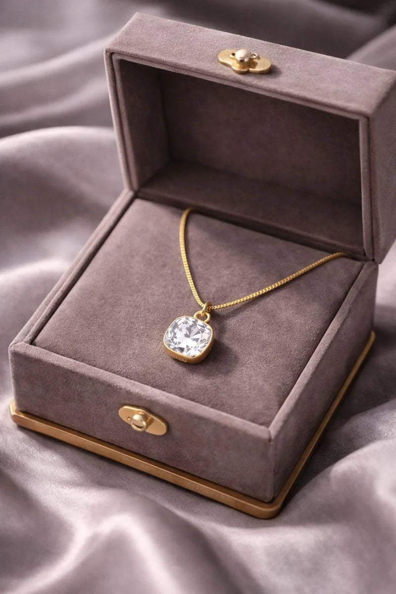 A crystal pendant with a metal chain, presented in a gift box